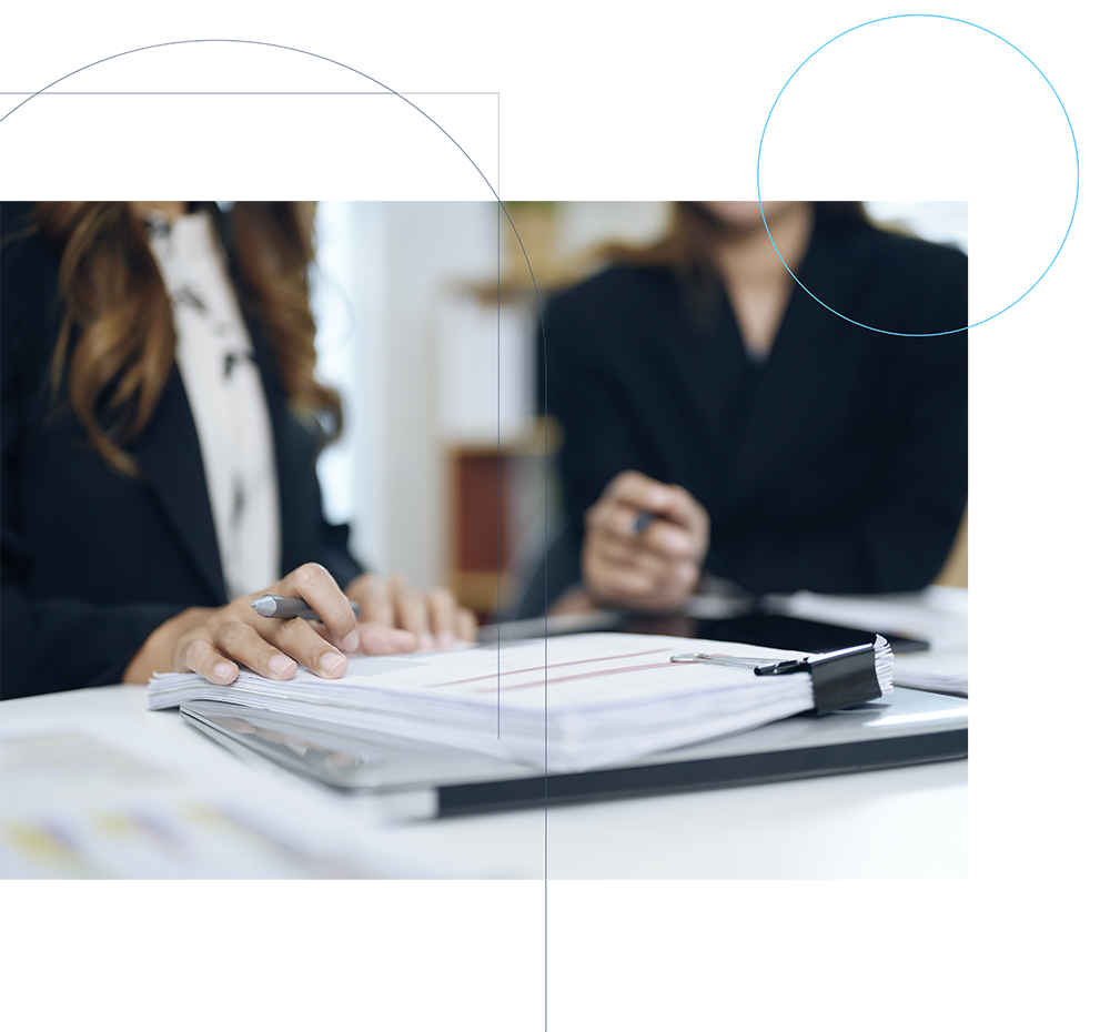 two professional businesswomen discussing financial paperwork office